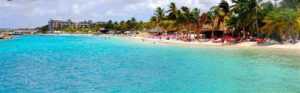 Tropisch wit zandstrand met helder blauw water op Curaçao, ideaal voor een strandvakantie