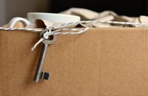 Zwangere vrouw plant verhuizing met checklist en organiseert dozen voor babykamer