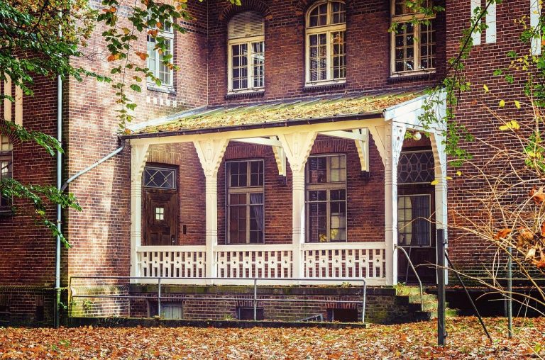 Gezellig ingerichte veranda met hoekbank, lage tafel, planten en warme verlichting voor optimale sfeer