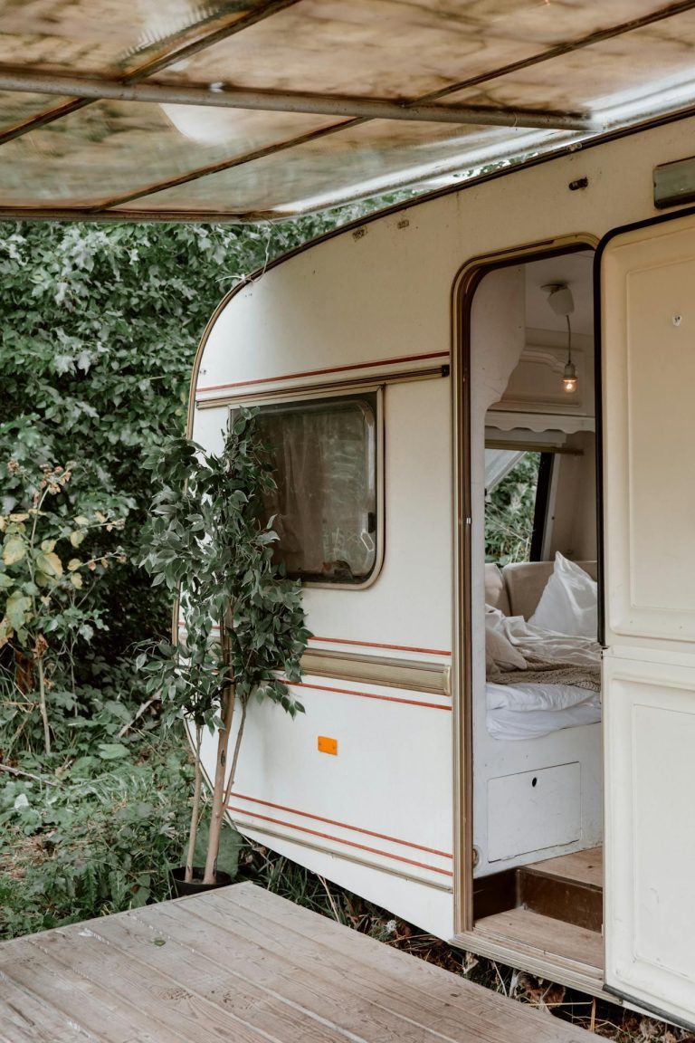 Man werkt aan laptop met geld en financiële documenten, illustreert caravan verkopen